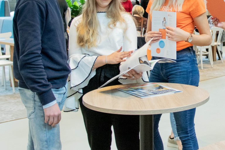 Studiekiezers en een student staan samen op de open dag 