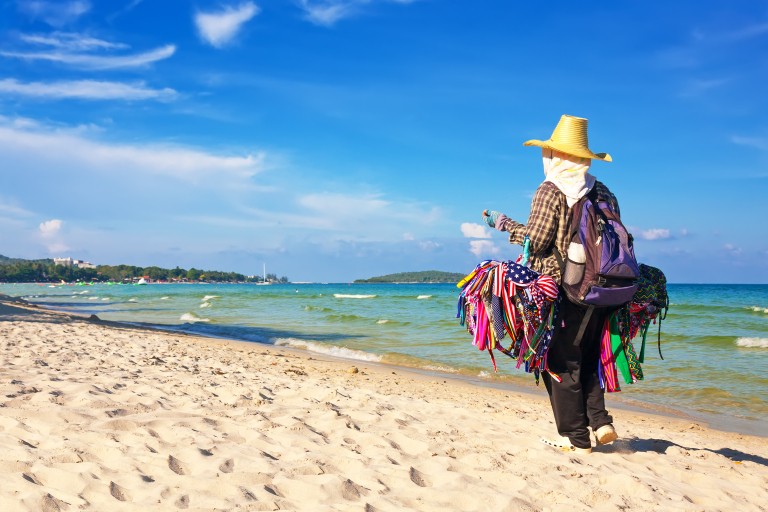 Een verkoper wandelt over het strand