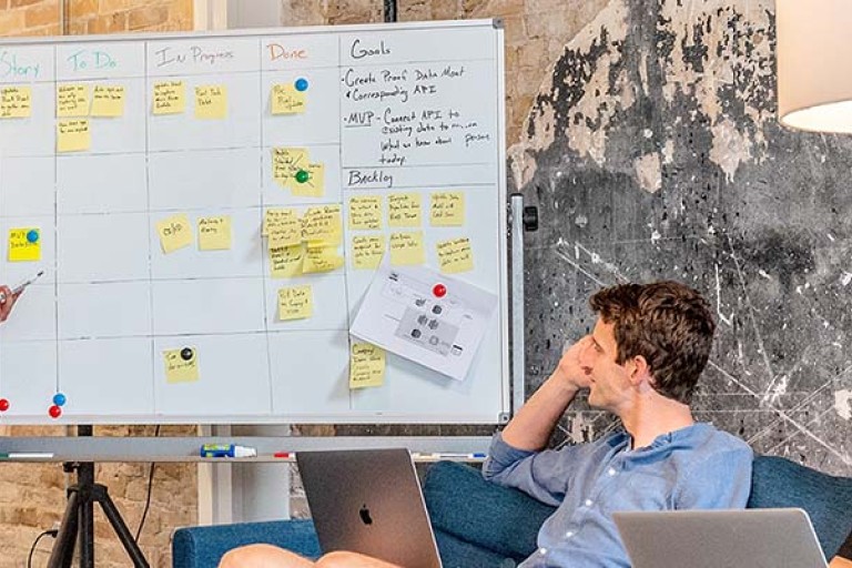 Iemand houdt een presentatie voor een groepje mensen