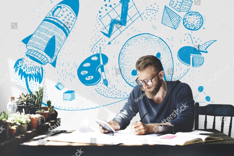 Een man schildert aan een bureau