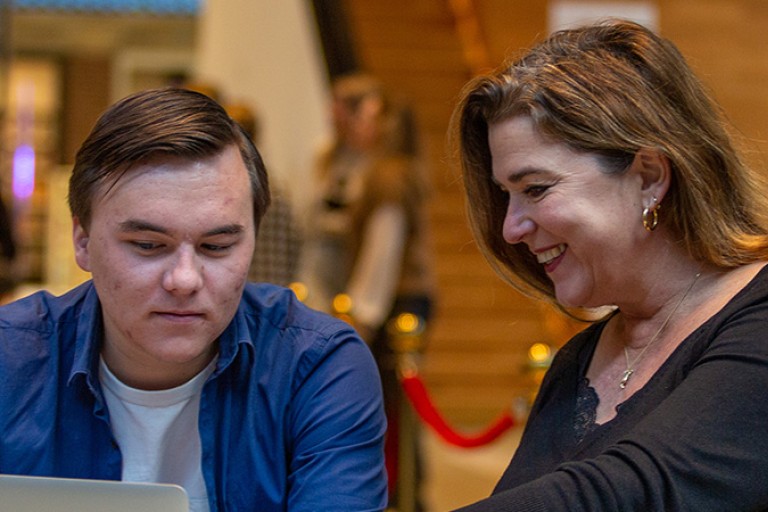 Een ouder en studiekiezer werken samen op een laptop