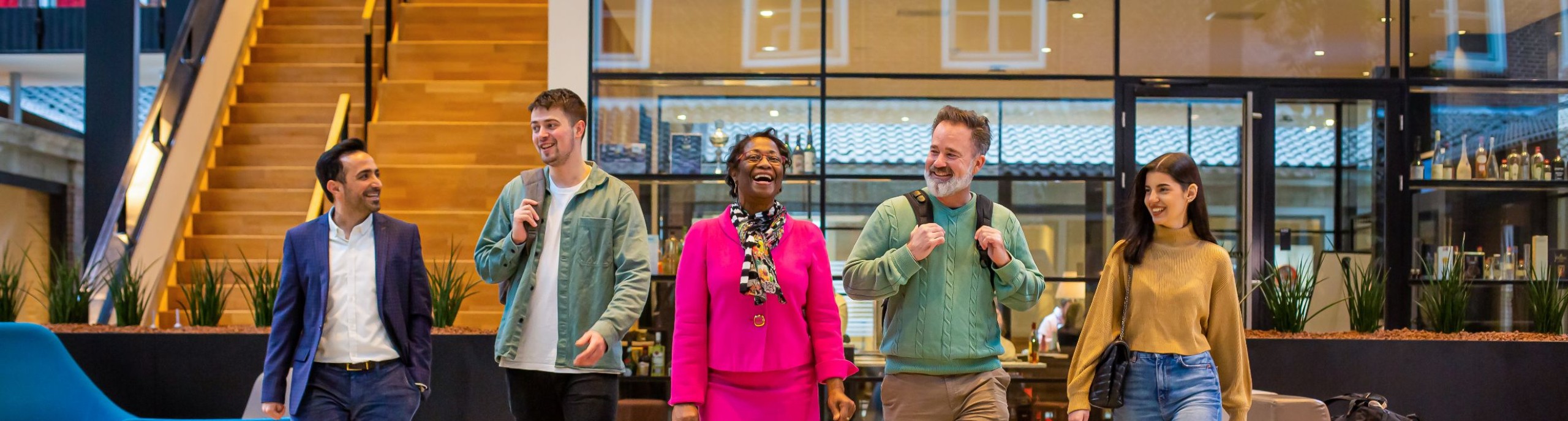 Studenten en docenten lachend op een rij