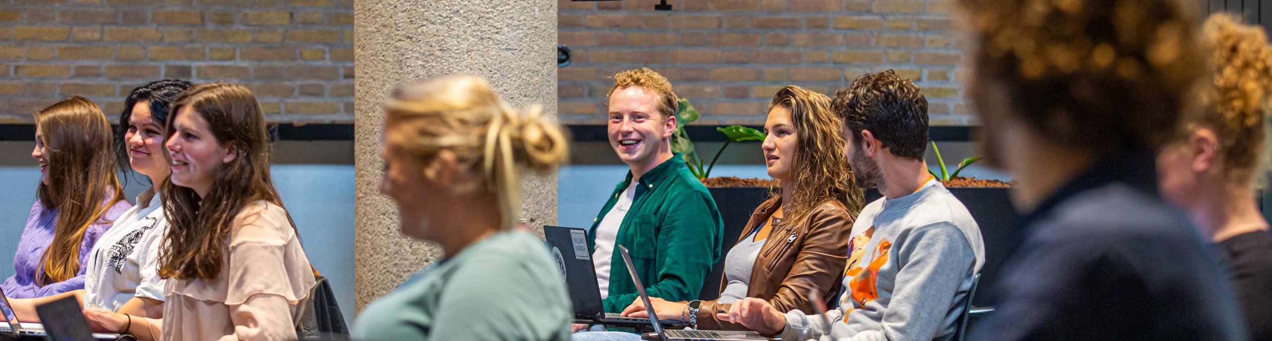 Studenten met een laptops luisteren naar een uitleg