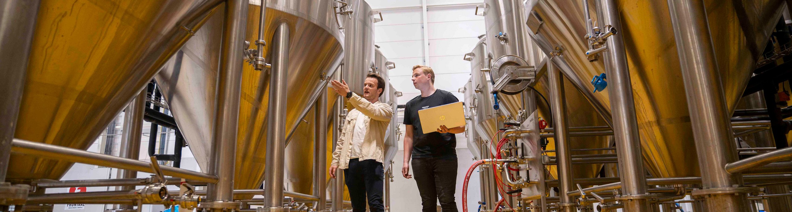 Twee mannen lopen in een brouwerij