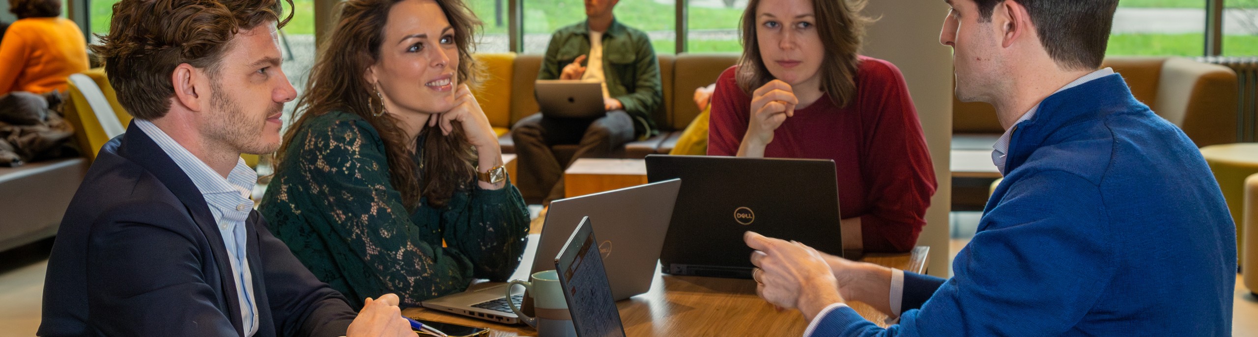 Vier mensen overleggen aan een tafel