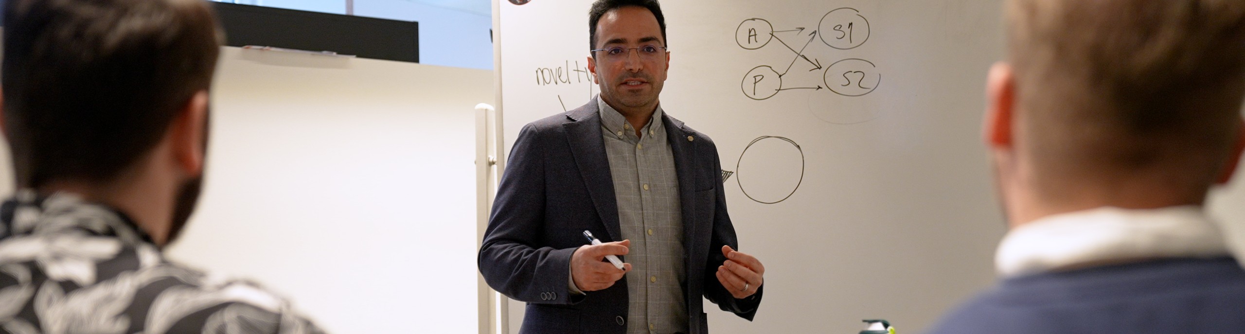 Een docent geeft uitleg voor een whitebord