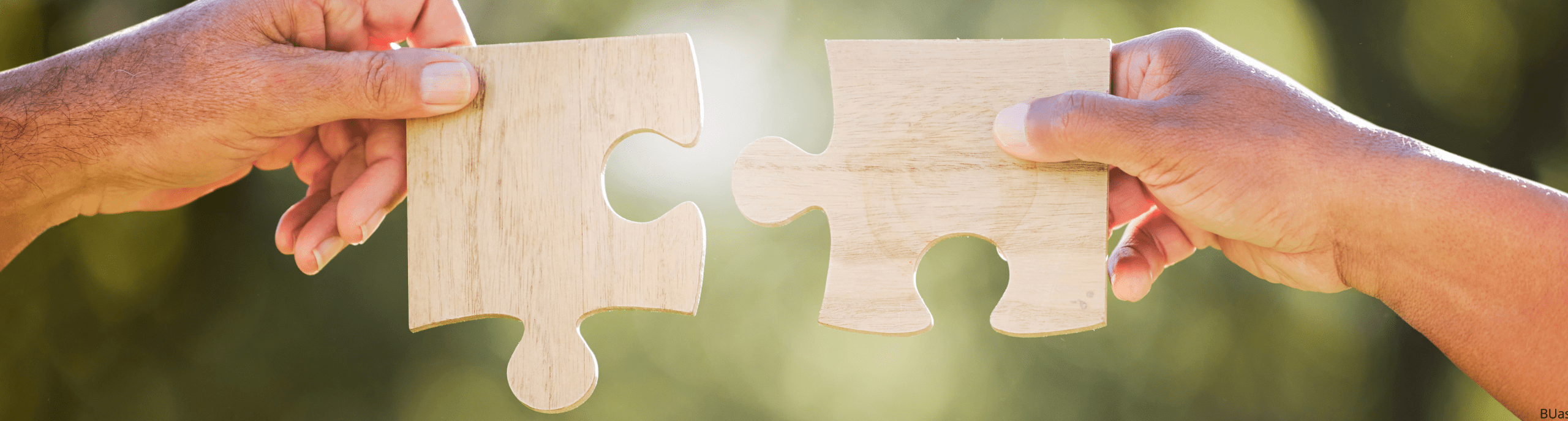 Twee handen houden twee puzzelstukken vast