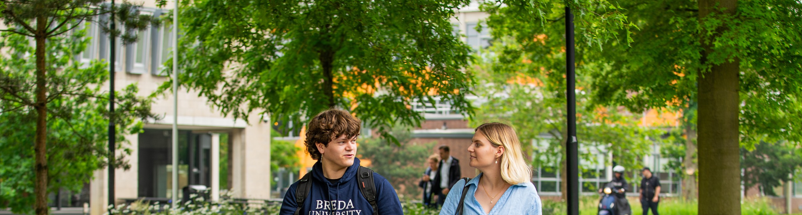 Een student en studiekiezer lopen over de BUas campus