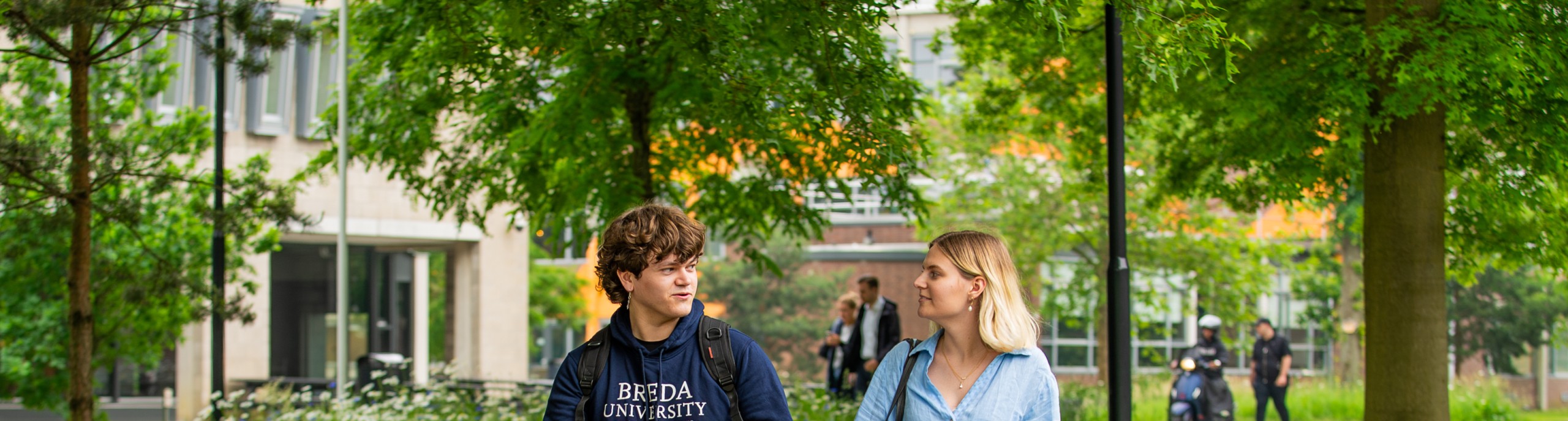 Een student en studiekiezer lopen over de BUas campus