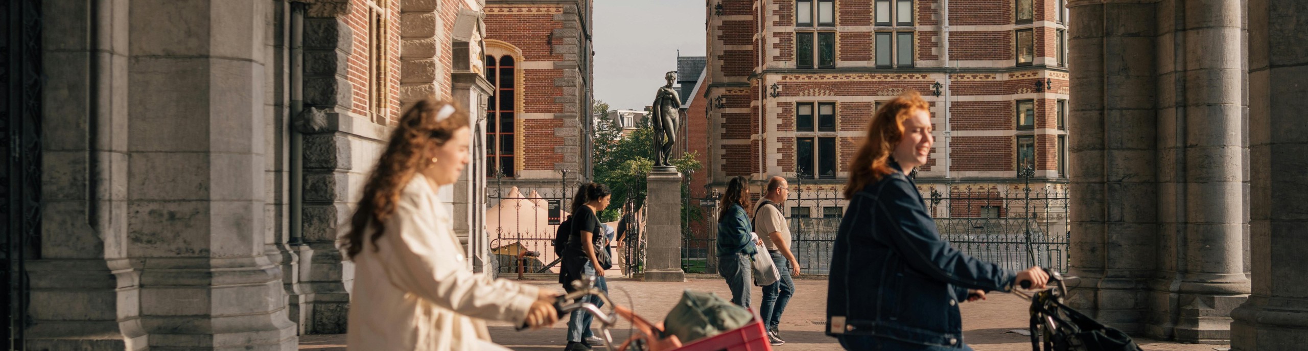 Places & flows: Twee meisjes fietsen langs het Rijksmuseum.