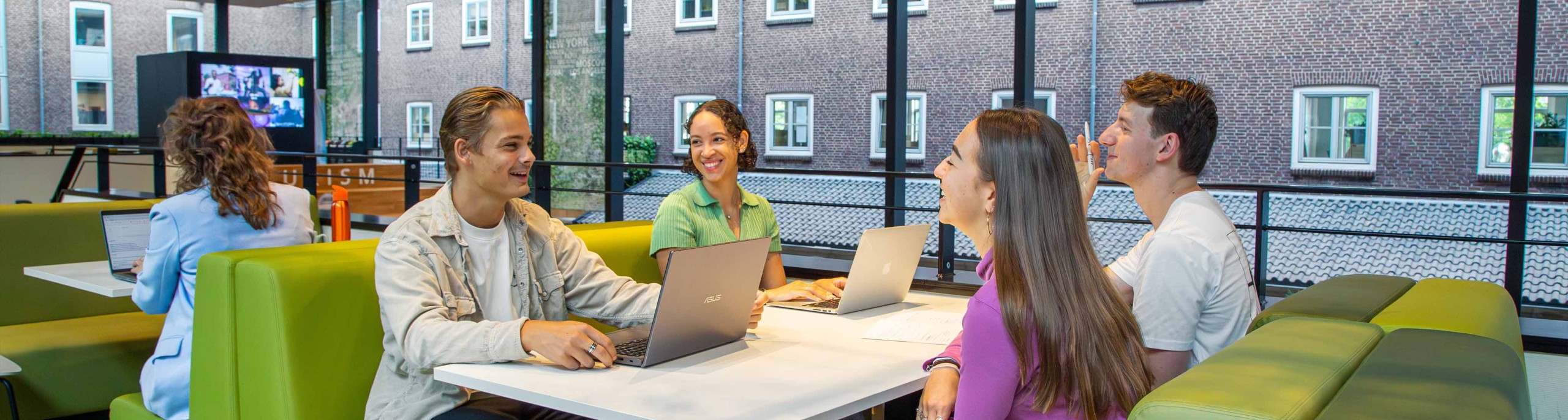 Vier studenten werken samen aan een tafel 