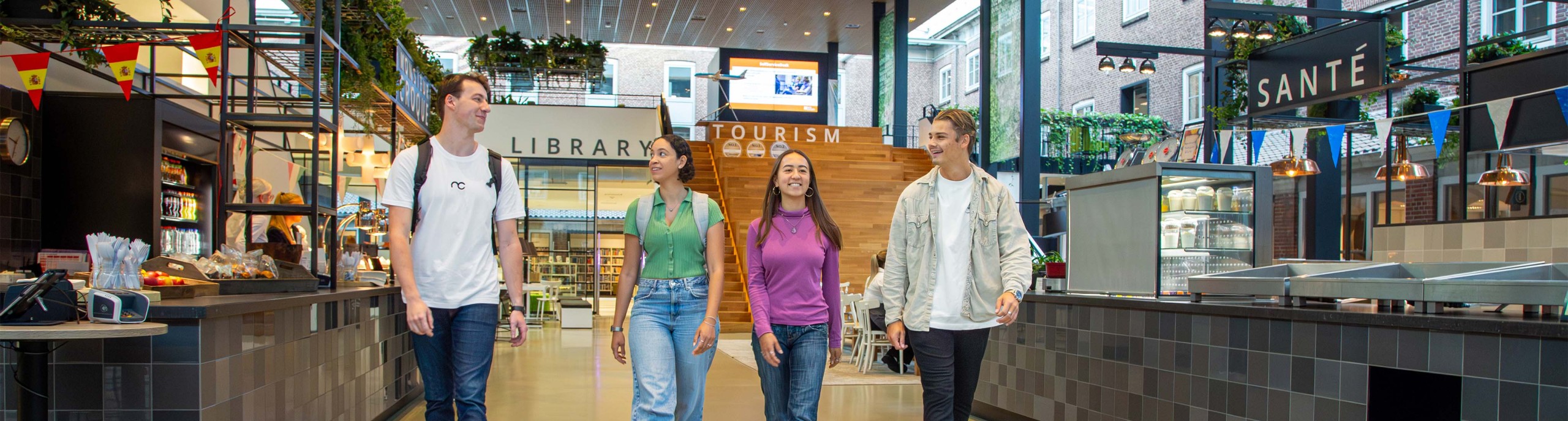 Vier studenten lopen door een BUas gebouw