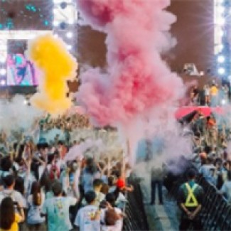 Gekleurde rook tussen dansende mensen op een festival