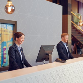 Twee mensen staan achter een receptiebalie