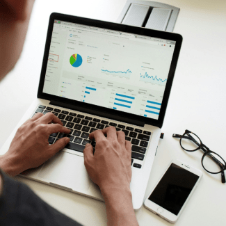 Een student werkt op een laptop met grafieken