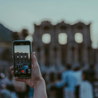 Een toerist maakt een video van een oud gebouw