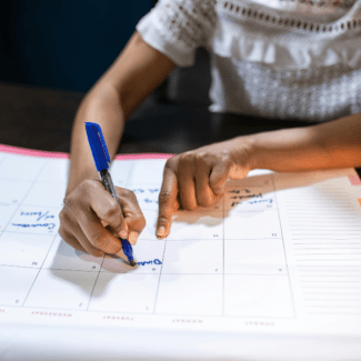 Een vrouw schrijft iets op een kalender