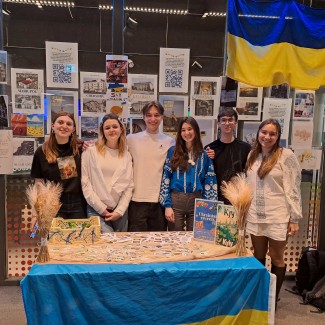 Studenten staan achter een tafel met de Oekraïnsche vlag