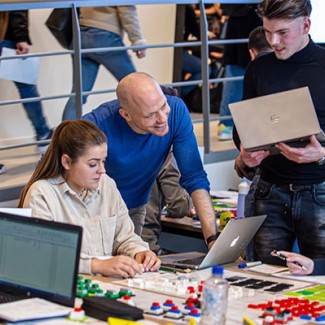 Een docent bekijkt het werk van studenten op hun laptop