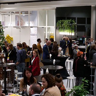 Studenten en docenten praten in een ruimte met statafels