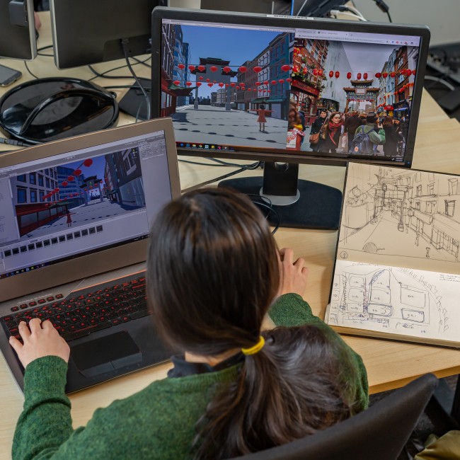 Een student ontwerpt een game op verschillende schermen