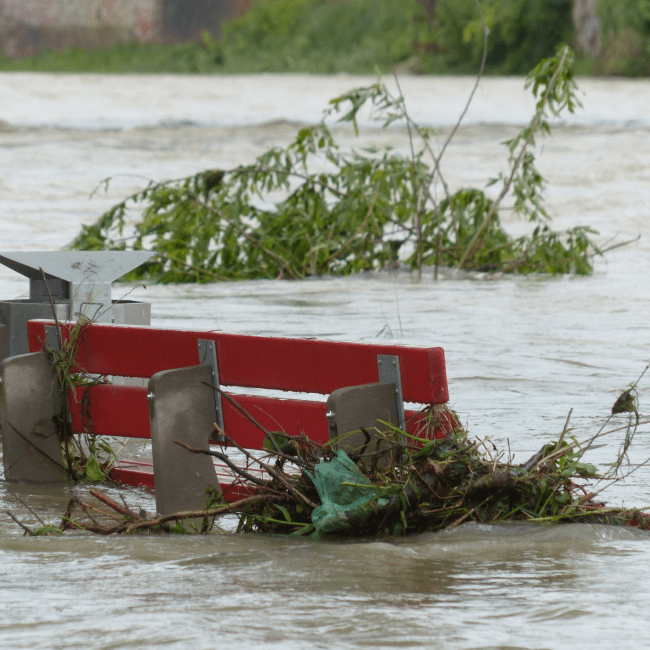 Een bankje staat bijna onder water tijdens een overstroming