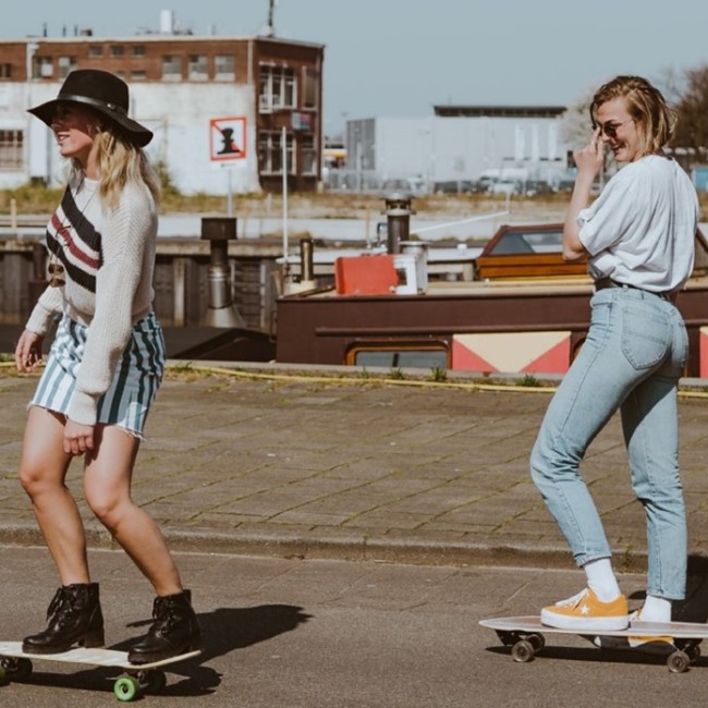 Twee studenten op een skateboard