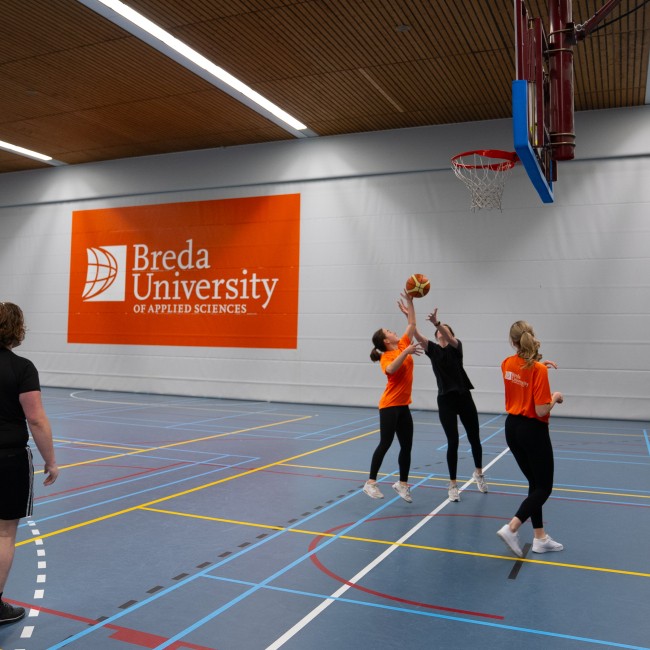 Vier studenten spelen basketbal
