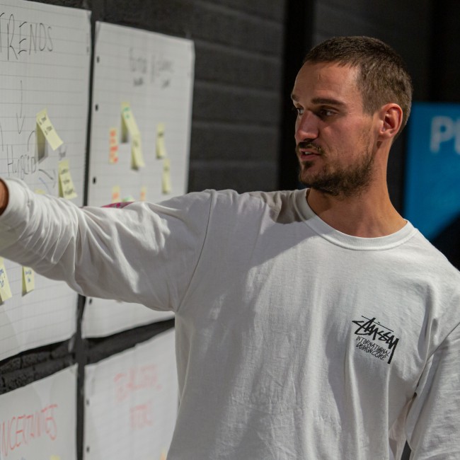 Een student wijst iets aan op een post-it