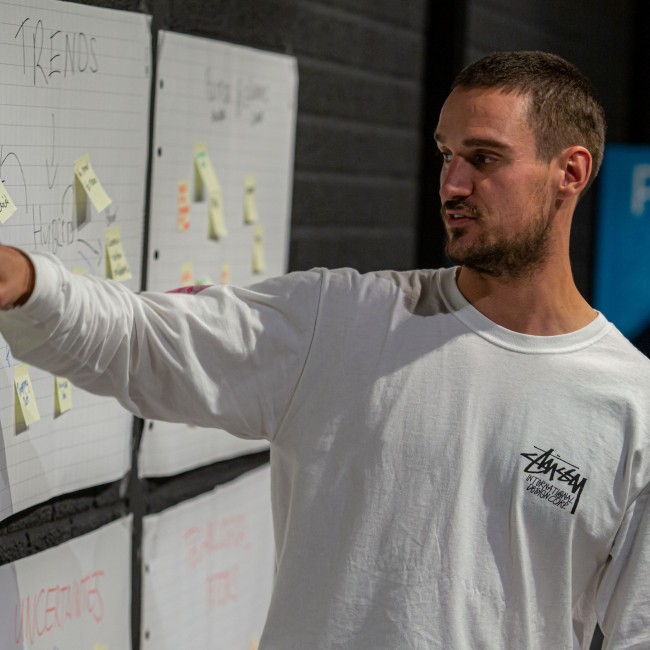 Een student wijst een post-it aan 