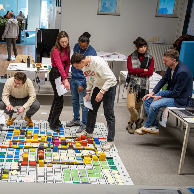Studenten werken samen aan een groot model van een stad 