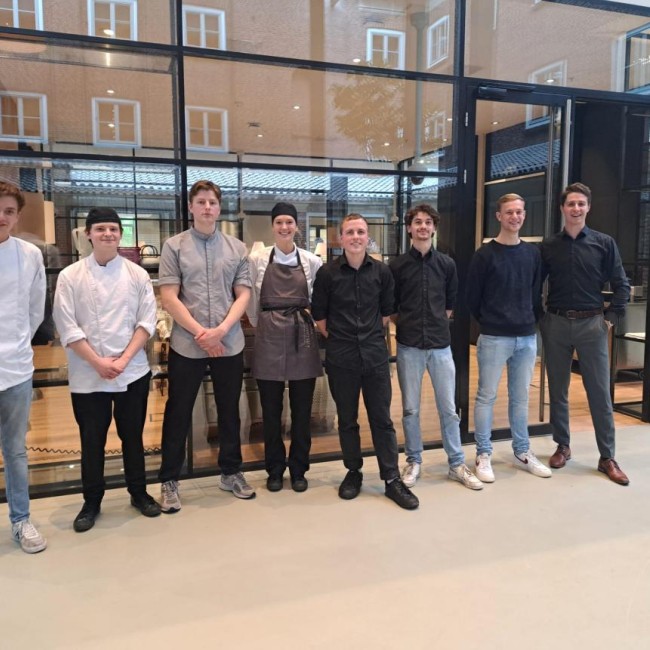 Groepsfoto van studenten in restaurant werkkleding 