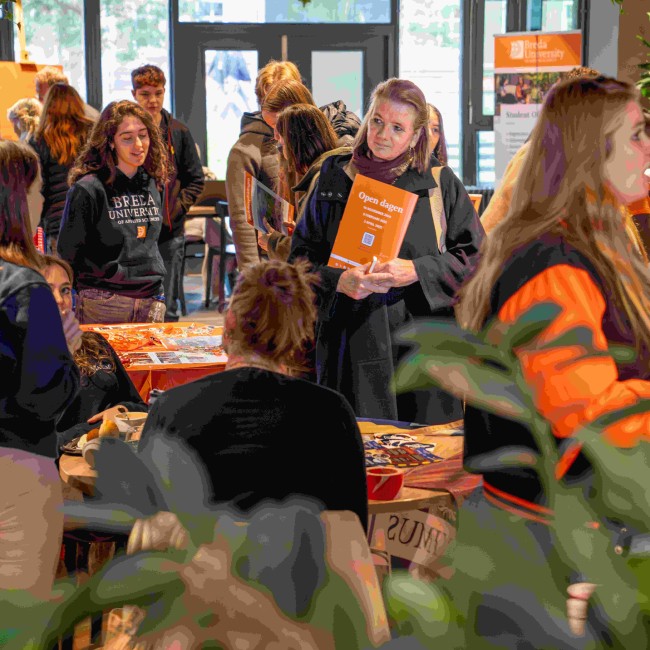 Een ouder staat bij de informatiestand tijdens een open dag