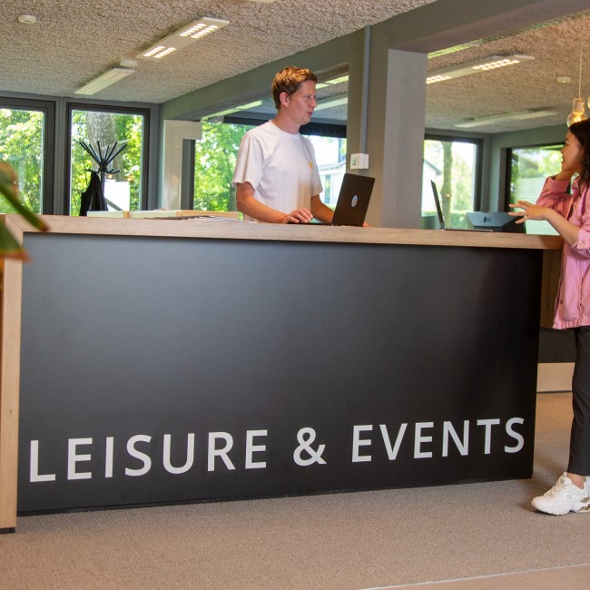 Een student wordt geholpen bij de Leisure & Events balie