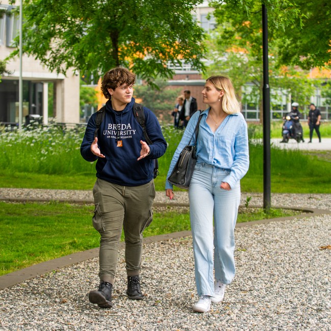 Een student en studiekiezer lopen over de BUas campus