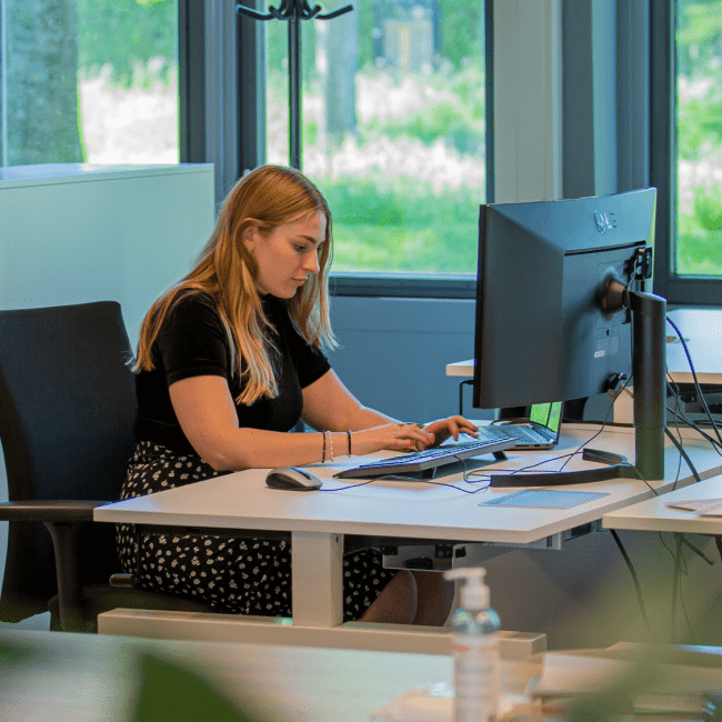 Een student werkt aan een desktopcomputer