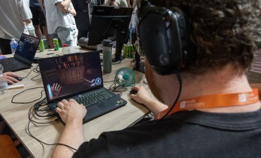 Een student laat een computerspel zien tijdens de Showcase Day