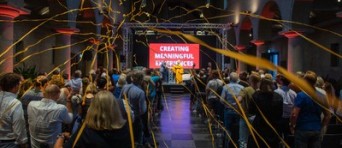 Linten vliegen door een zaal met een publiek en een podium