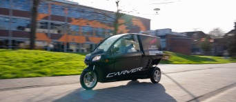 Een auto op drie wielen rijdt over de BUas campus