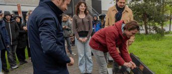 Jorrit Snijder en anderen kijken naar de opening van een bankje