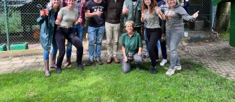 Groepsfoto van mensen voor een kippenhok