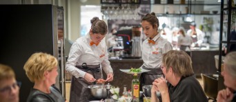 Twee studenten dienen borden op in een restaurant 