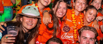 Groepsfoto van feestende studenten tijdens het uitgaan