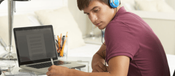 Student aan het werk met een koptelefoon op