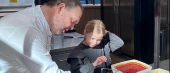 Kok legt aan kind uit hoe je een pizza maakt