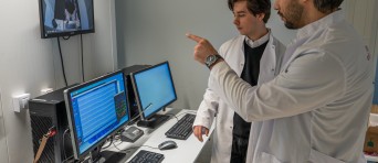 Twee onderzoekers analyseren resultaten op een computer