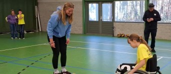 Meisje in een rolstoel sport in een gymzaal