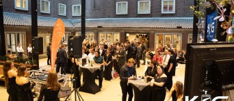 Gasten van het event staan aan verschillende sta-tafels