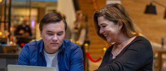 Een ouder en studiekiezer werken samen op een laptop